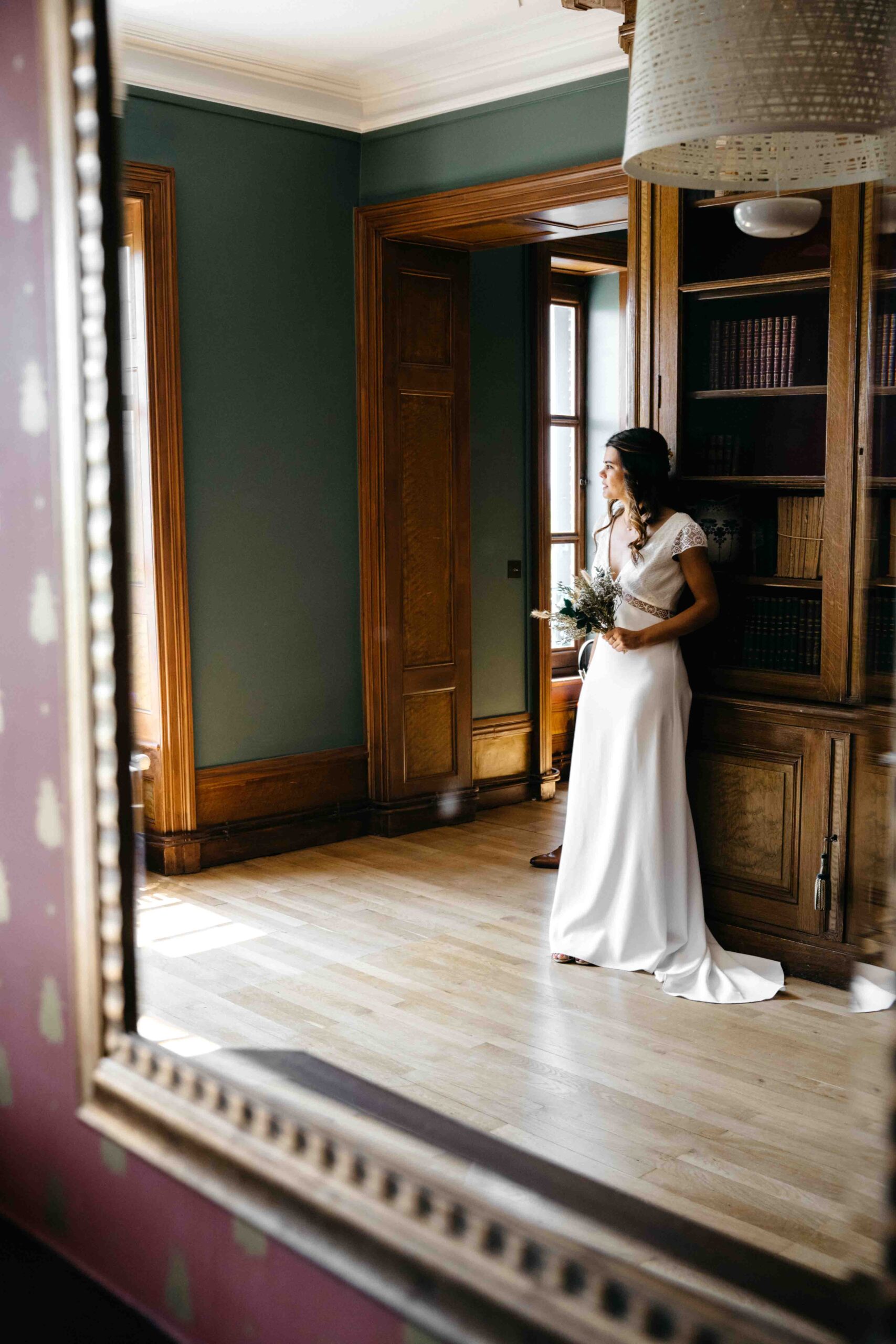 photos dans le miroir duquel on aperçoit la mariée adossée à la bibliothèque