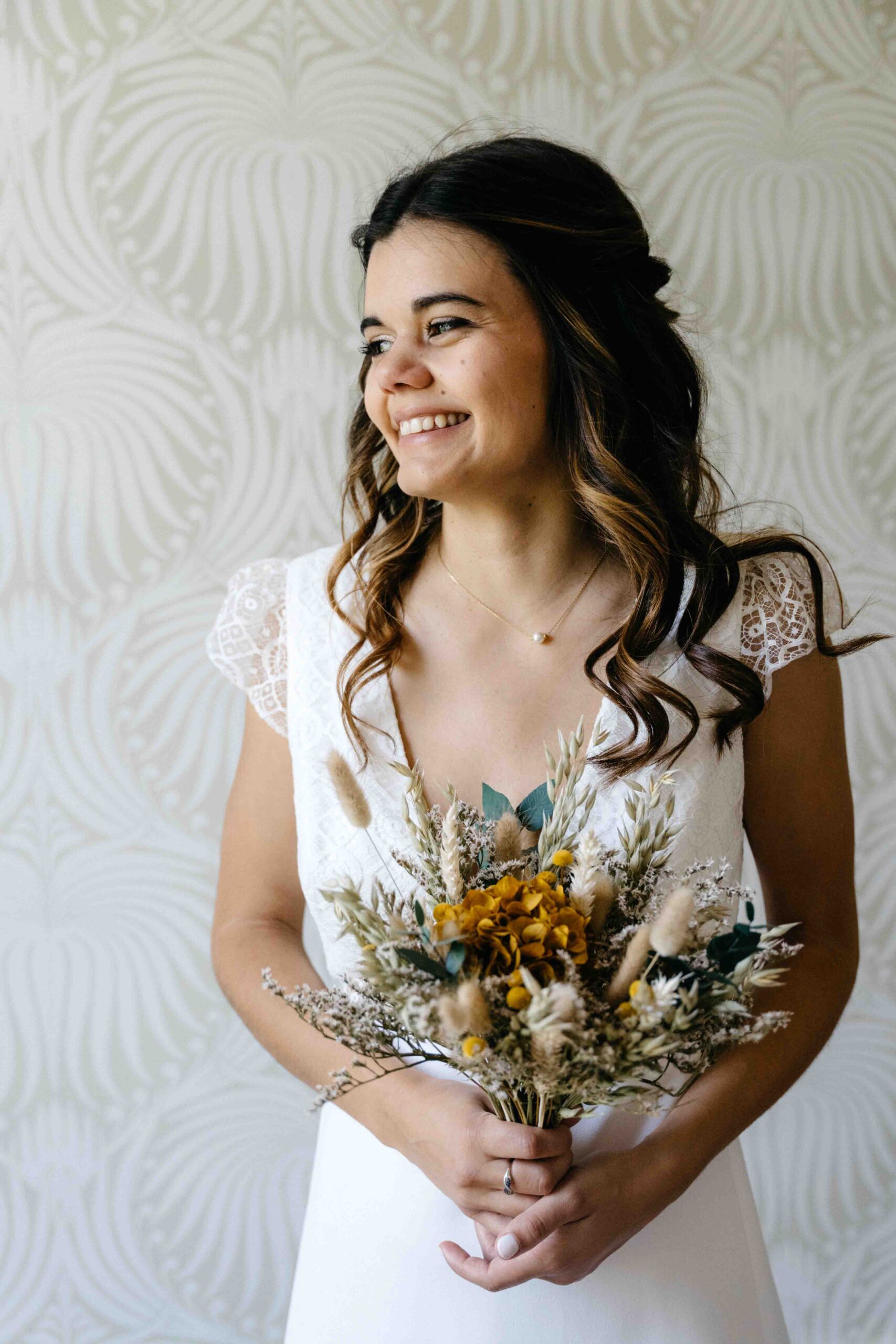 portrait de la mariée tenant son bouquet et regardant dehors