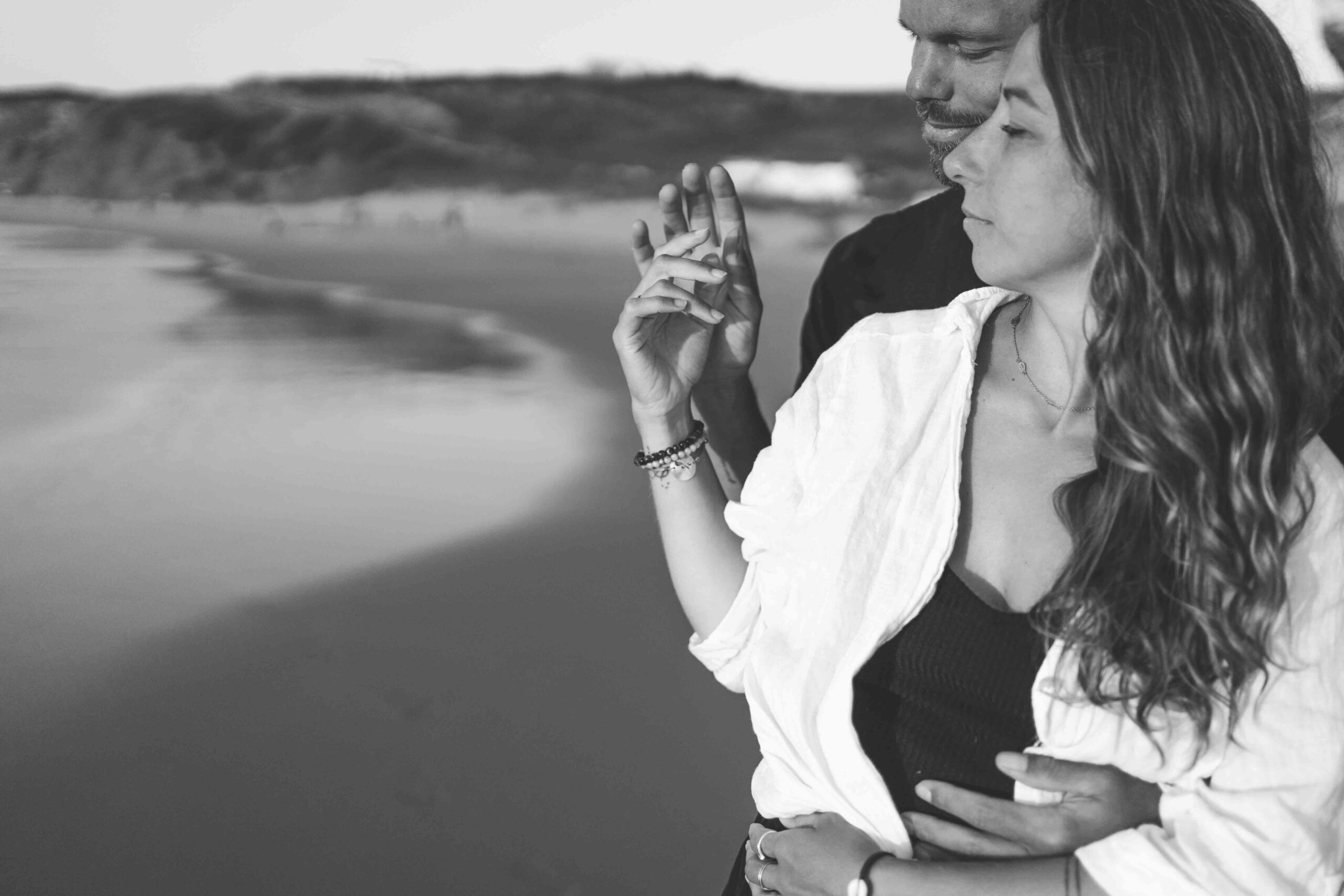 photo de couple se tenant la main sur la plage au couché de soleil au Portugal