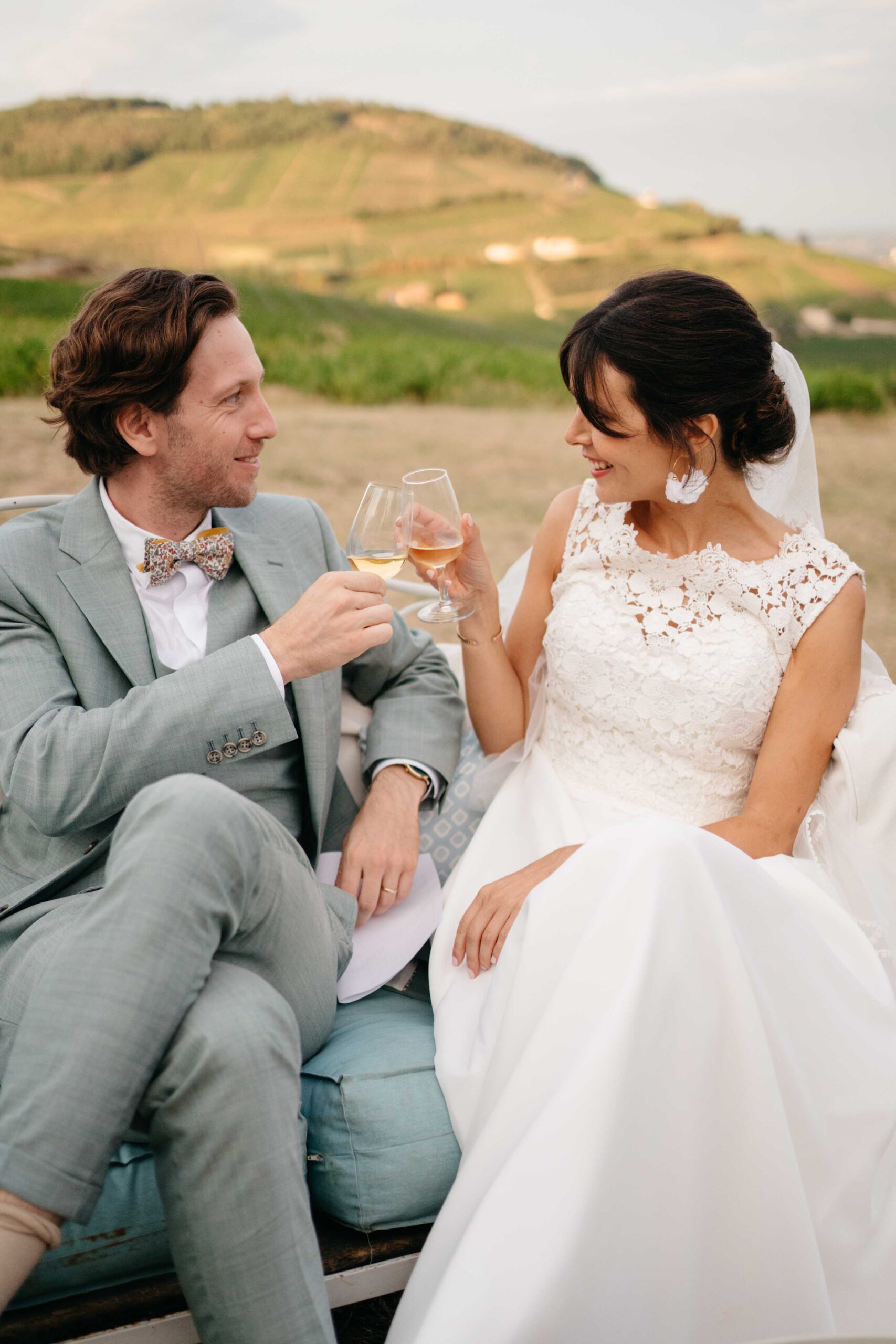 les mariés trinquent devant les vignes dans le beaujolais , au lieu de réception de mariages de l'ermitage
