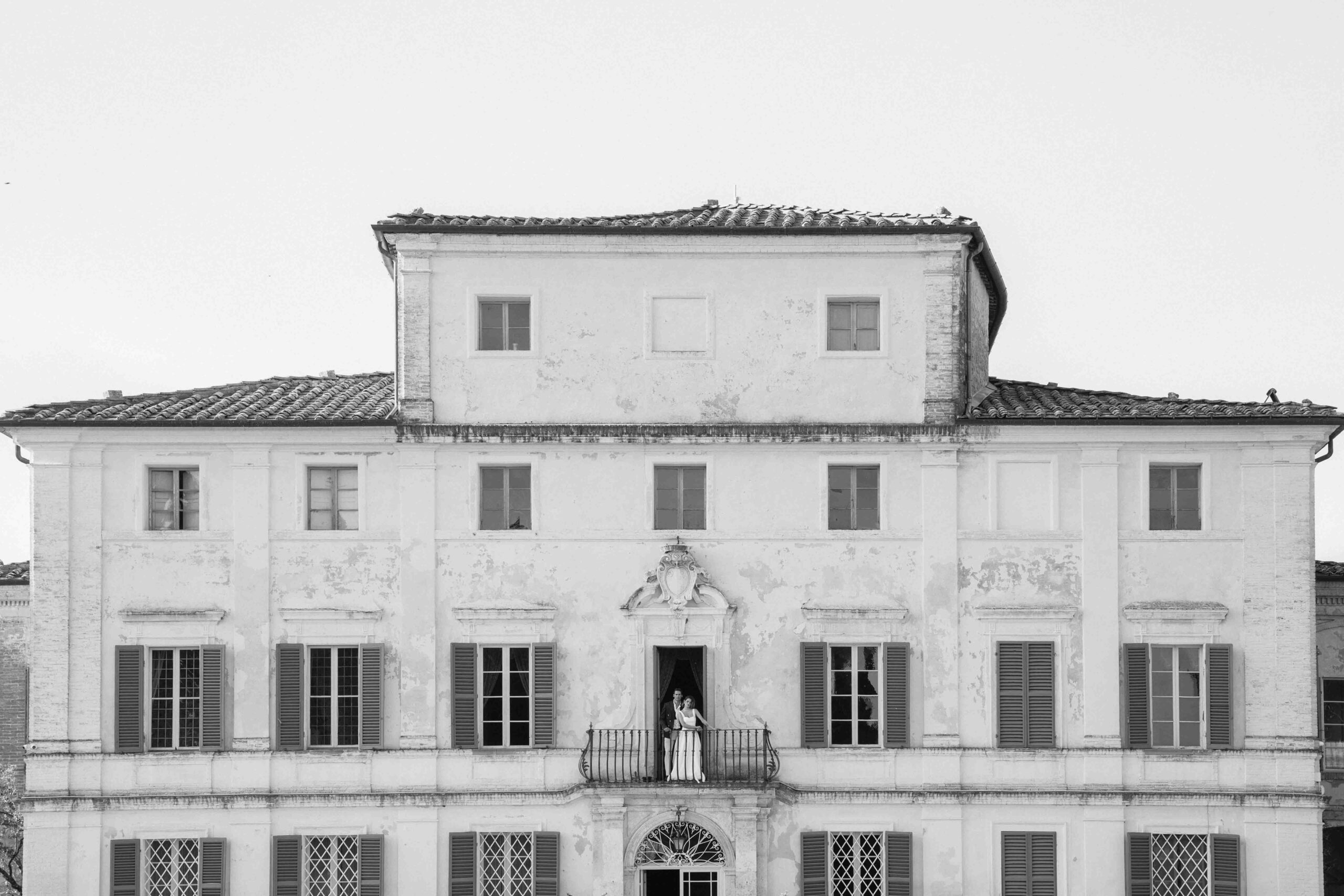 wedding in tuscany, Italy, the married couple is standing at the balcony of the tuscan old villa