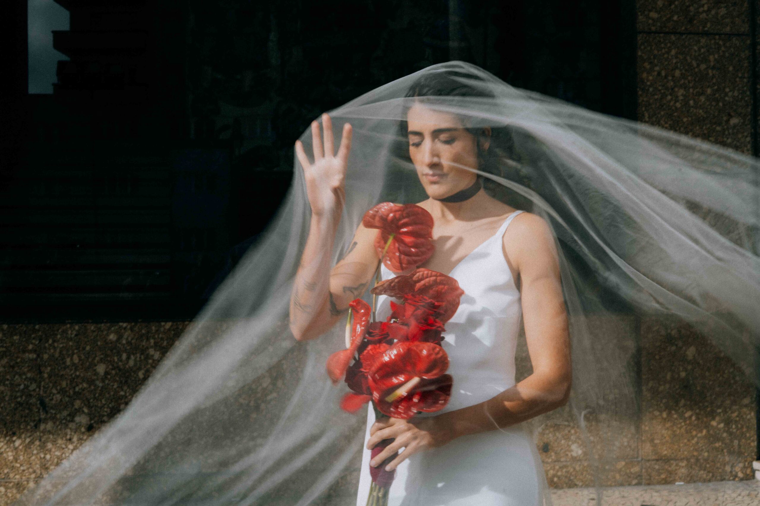 bride portrait under the veil with a red bouquet in porto