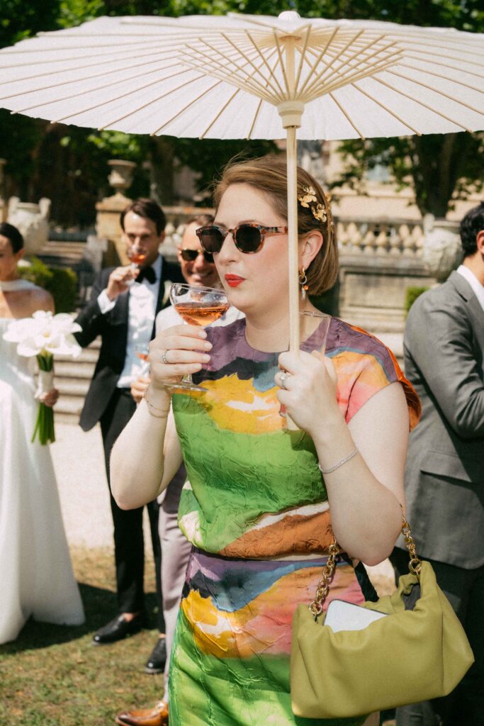 guest drinking champagne under umbrella during cocktail