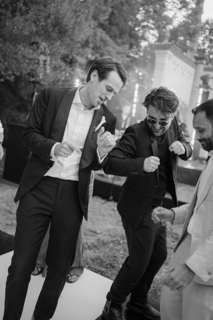 groom dancing with friends during the party outside