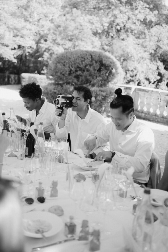 guest filming his friends with a super 8 vintage camera during dinner